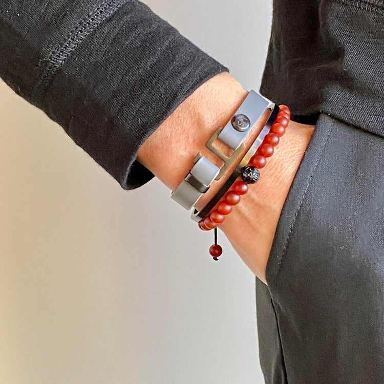 With a trendy, cool modern vibe, this charcoal grey/navy blue leather cuff bracelet is paired with your choice of brushed stainless steel, brass or black ceramic hardware. Our signature cuff bracelet is a modern staple for your WristBend collection. Made by WristBend