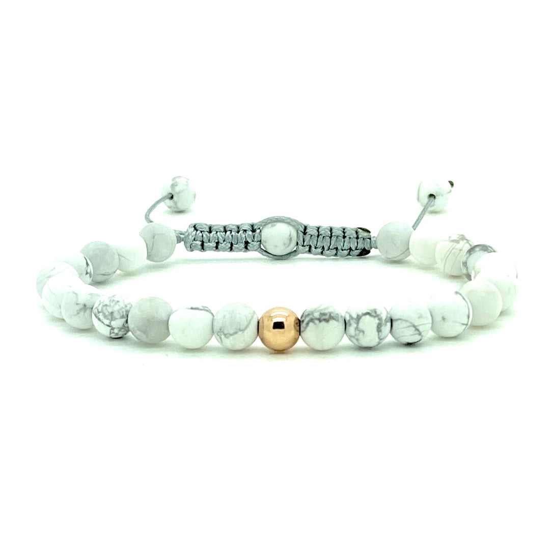 Howlite is a stone of patience and perspective. These smooth white beads are accented with your choice of solid 14K white, rose and yellow gold beads. Hand knotted adjustable cord for a perfect fit. Made by WristBend