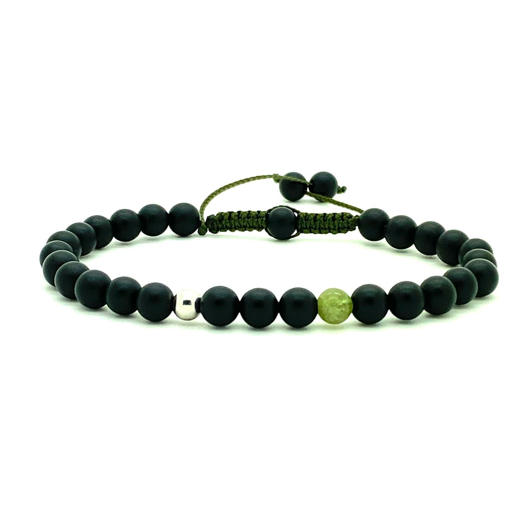 Trendy black matte onyx beads accented with a single green garnet bead, and your choice of a 14K solid white, rose or yellow gold bead. Hand knotted adjustable cord for a perfect fit. Made by WristBend