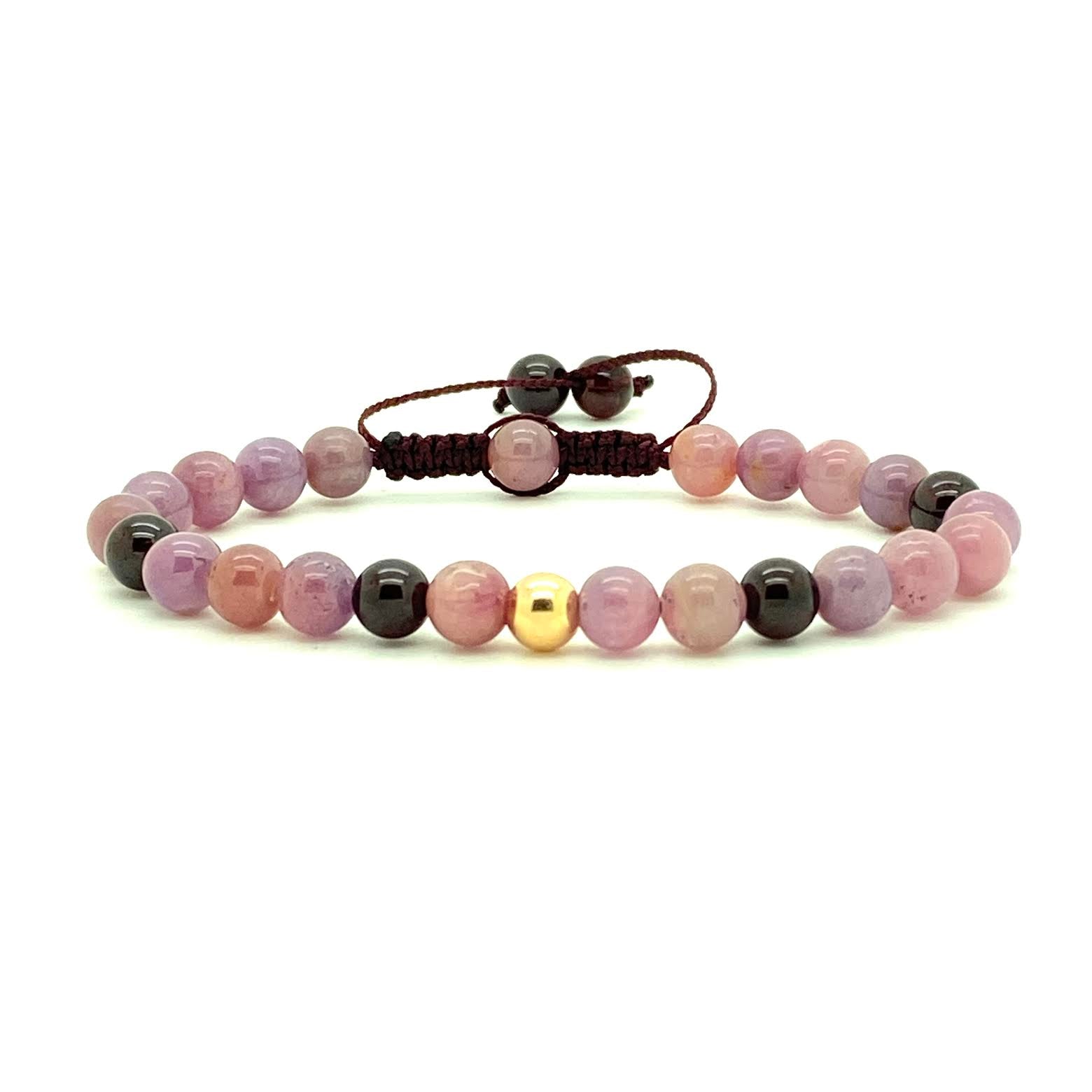 Pink Rubies honor the higher mind, bringing intuition, clarity and self-mastery. These smooth pink variety gemstones are accented with Garnet beads and your choice of a 14K solid yellow, rose or white gold bead. Hand knotted adjustable cord for a perfect fit. Made by WristBend  