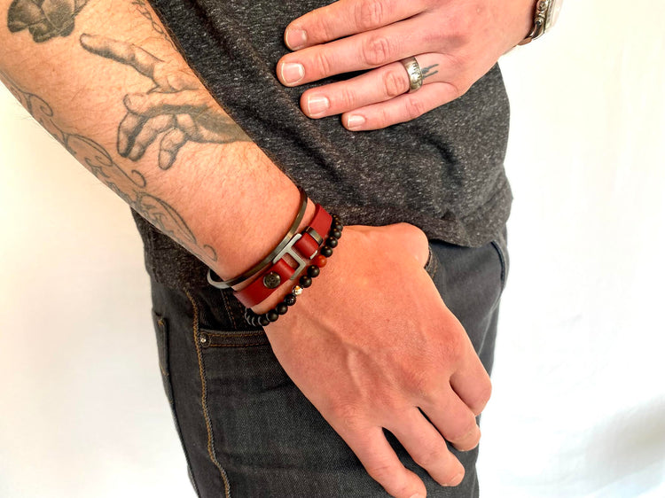 With a trendy, cool modern vibe, this burgundy/black Italian leather cuff bracelet is paired with your choice of brushed stainless steel, brass or black ceramic hardware. Our signature cuff bracelet is a modern staple for your WristBend collection. Made by WristBend
