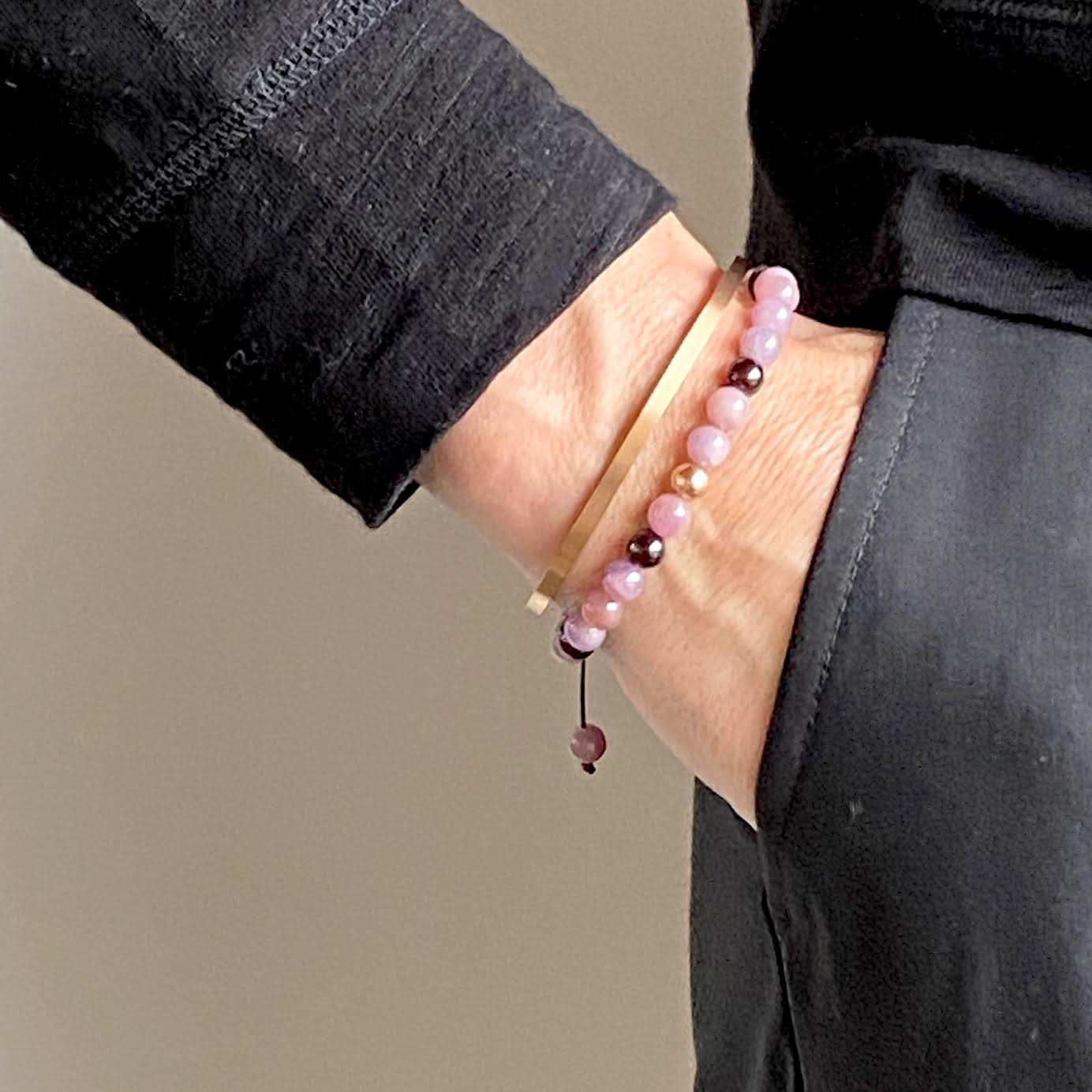 Pink Rubies honor the higher mind, bringing intuition, clarity and self-mastery. These smooth pink variety gemstones are accented with Garnet beads and your choice of a 14K solid yellow, rose or white gold bead. Hand knotted adjustable cord for a perfect fit.  Made by WristBend