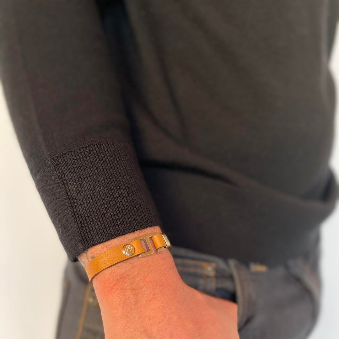 With a trendy, cool modern vibe, this tan/dark brown Italian leather cuff bracelet is paired with your choice of brushed stainless steel, brass or black ceramic hardware. Our signature cuff bracelet is a modern staple for your WristBend collection. Made by WristBend
