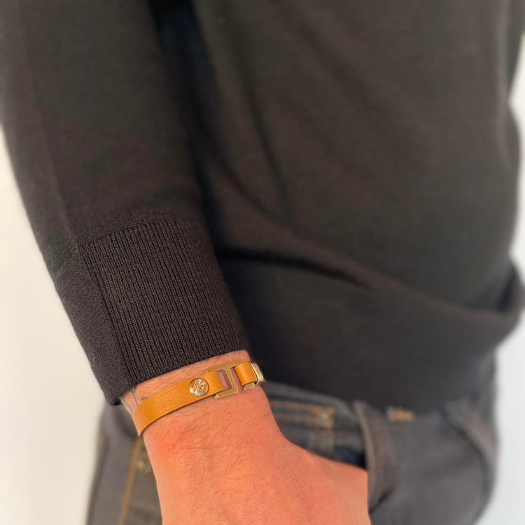 With a trendy, cool modern vibe, this tan/dark brown Italian leather cuff bracelet is paired with your choice of brushed stainless steel, brass or black ceramic hardware. Our signature cuff bracelet is a modern staple for your WristBend collection. Made by WristBend