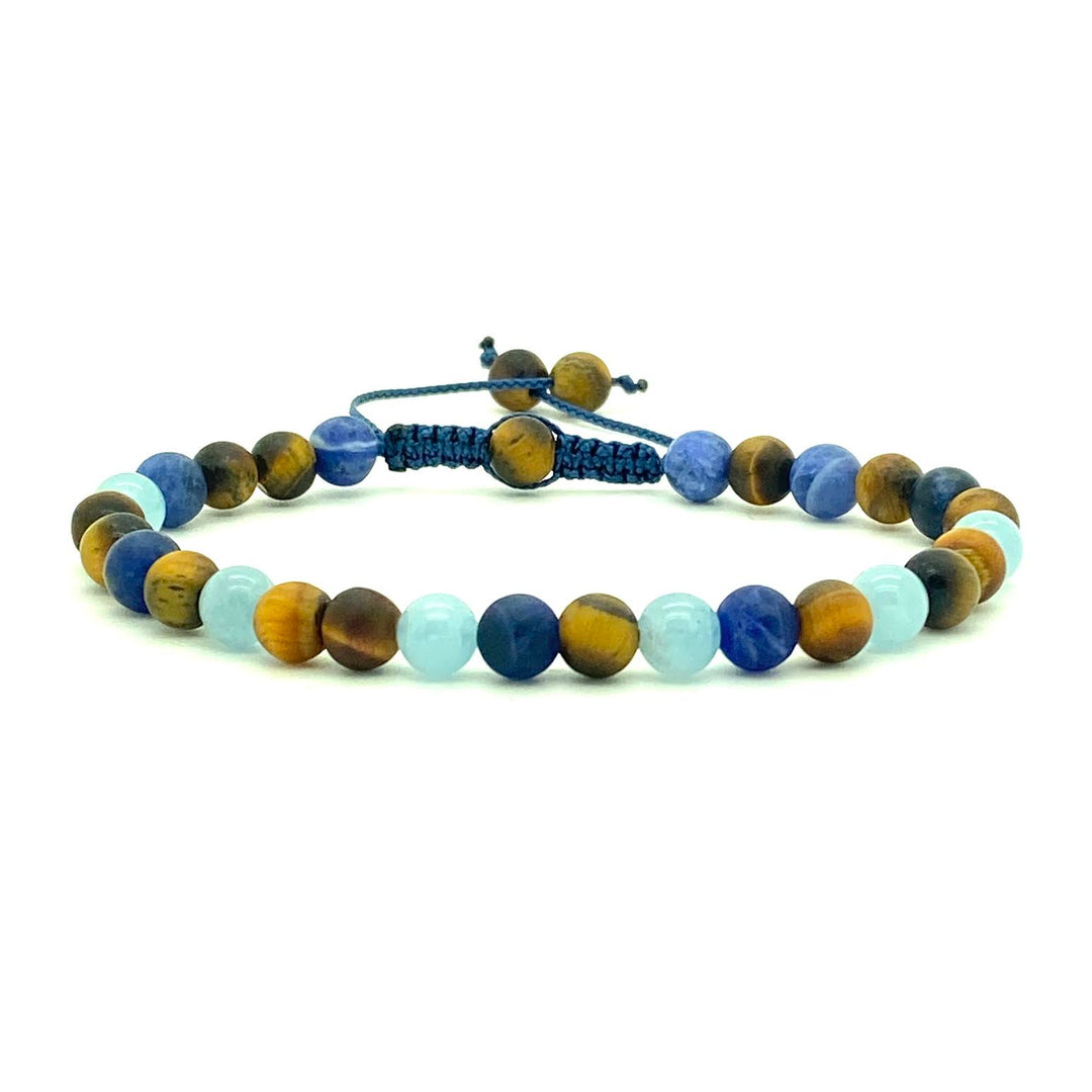 The rich celestial shades of blue remains a symbol of deep honor and loyalty and represents truth and wisdom universally. Paired with beautiful Tiger's Eye beads. Hand knotted adjustable cord for a perfect fit. Made by WristBend