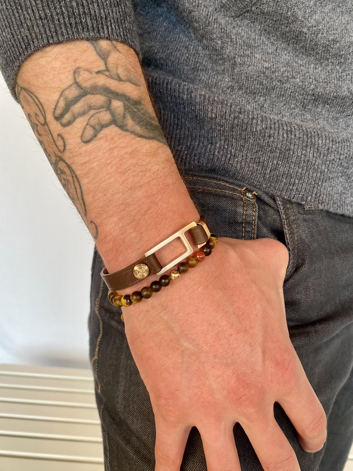 Our striking dark brown/tan Italian leather bracelet is paired perfectly with our artisan designed, lightly brushed hardware. Your hardware choices include Rose Gold, Yellow Gold, Stainless Steel or Black Ceramic. This adjustable size bracelet is a distinctive piece worn alone or with a WristBend stacking bracelet. Made by WristBend